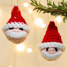 two christmas ornaments hanging from a tree with lights in the background