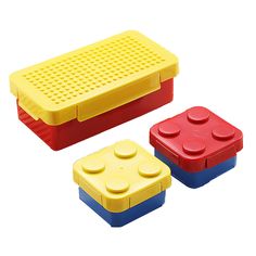 three lego style lunch boxes with lids and handles, one in red, one in yellow