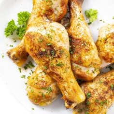 some chicken is on a white plate with parsley