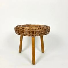 a wicker stool with wooden legs on a white background in the shape of a basket