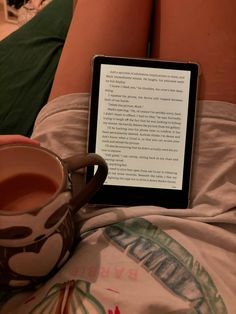 a person laying in bed with their legs crossed holding a tablet