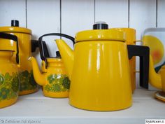 yellow teapots and cups are sitting on the shelf next to eachother