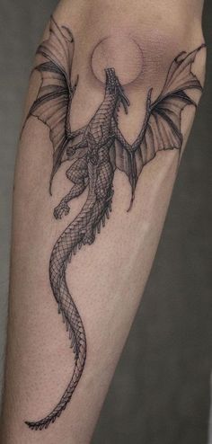 a black and grey dragon tattoo on the right leg, it appears to be flying