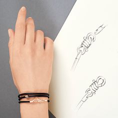 a woman's hand holding onto a piece of paper with two bracelets on it