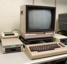 an old computer sitting on top of a desk next to a small keyboard and monitor