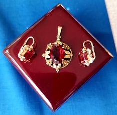 Antique set consisting of a pair of earrings and flower pendant. Bright red crystal set in gilded silver (Ag 900/1000), all three pieces are hallmarked. There are three hallmarks, confirming its silver purity, origin and age.  Made in then Austro-Hungarian Empire, in the Czech lands, in 1890's. Original authentic set from a private family collection.  Earrings are in perfect condition, closing is fully finctional. The large red crystal from the pendant is unfortunately slightly chipped off. It i Austro Hungarian, Set Earrings, Crystal Set, Red Crystals, Flower Pendant, Antique Victorian, Czech Republic, Favorite Jewelry, Jewelry Necklace Pendant