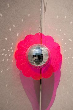 a disco ball hanging from the side of a pink flower