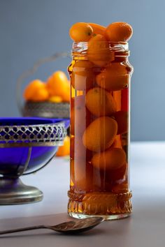 a jar filled with oranges sitting on top of a table