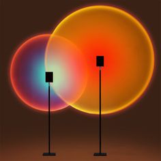 three different colored lights on poles in front of a brown background