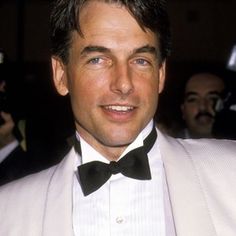 a man in a white suit and bow tie