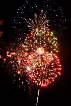 fireworks are lit up in the night sky with bright colors and sparkles on them