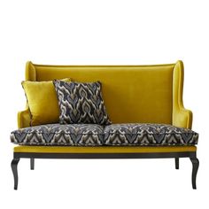 a yellow couch with black and white pillows on it's back end, sitting in front of a white background