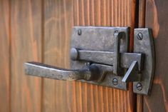 a close up of a door handle on a wooden door