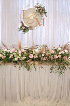 the table is decorated with flowers and greenery for an elegant wedding reception at l & m