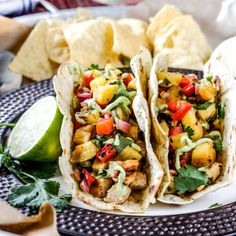 three tacos on a plate with chips and salsa