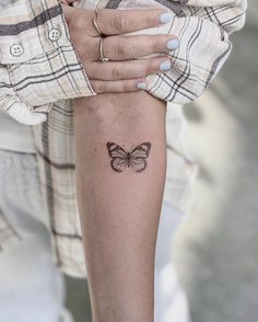 a woman's arm with a butterfly tattoo on it