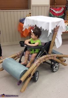 a small child sitting in a buggy made out of sticks and paper machs