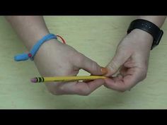 two hands holding pencils and an eraser