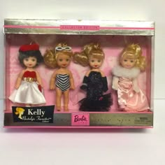 three dolls in a pink box with black and white dresses on them, one is wearing a tiara