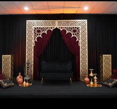 a stage set up with red curtains and gold accents for a wedding or special event