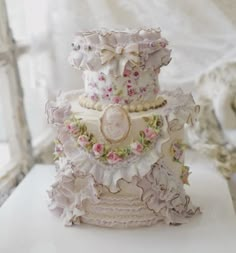 a three tiered cake decorated with pink and white flowers