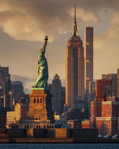 the statue of liberty in new york city, with skyscrapers in the back ground