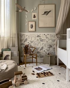 a child's room with toys and decor on the floor, including a rocking chair