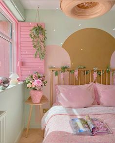 a pink and gold bedroom with flowers in vases on the headboard next to the bed