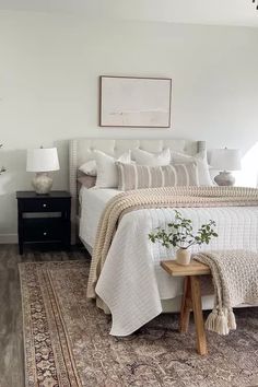 a bedroom with a large bed and rug on the floor