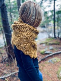 a woman standing in the woods wearing a yellow knitted cowl neckwarf