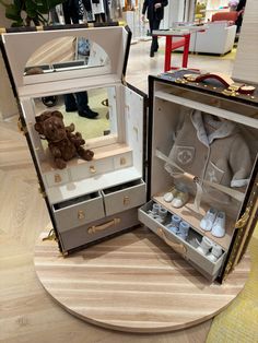 two open suitcases with stuffed animals in them on display at an indoor mall or showroom