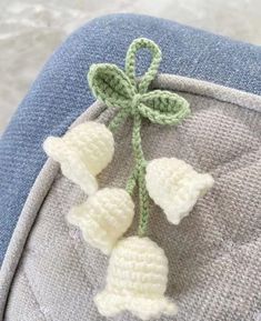 a crocheted flower is attached to the back of a blue chair with a green leaf