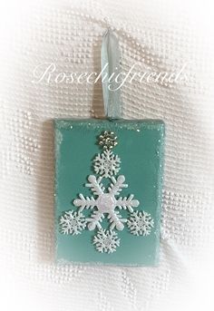 a snowflake ornament hanging on a white cloth