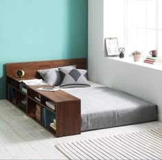 a bed sitting in the middle of a room next to a window with bookshelves