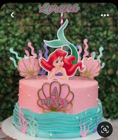 the little mermaid cake is decorated with pink and blue icing