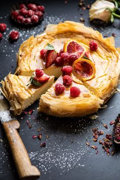 there is a pie with fruit on it and other toppings around the pie slice