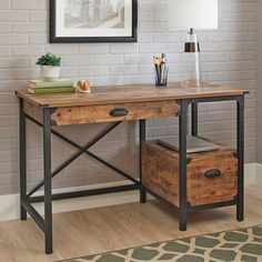 a wooden desk with two drawers under a picture frame on the wall next to a lamp