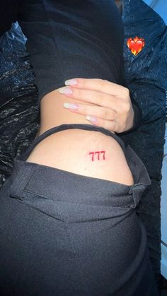 a woman's stomach with the word pi tattooed on her lower back, in red ink