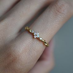 This dainty He loves me, Love Me Not Flower features four natural Australian opal hugged between two natural diamonds. Set on a 14K gold band with twisted details resemblance the stem of the flower. A beautiful dainty ring to wear on your finger to remind you of the beauty of life. Crafted in 14K solid gold in our NYC studio. 14K solid gold Natural Australian opals Natural round diamond 1.3mm ring band ** This item is specially made for you. Please allow 1-2 week lead time. Shipping:Domestic: Fr Opal Jewelry Gold, Dainty Flower Promise Ring, Delicate Moonstone Ring, Delicate Opal Wedding Ring, Delicate Opal Promise Ring, Delicate Gold Opal Ring, Nature-inspired Flower Promise Ring, Delicate Flower Ring For Weddings, Dainty Gold Flower Ring