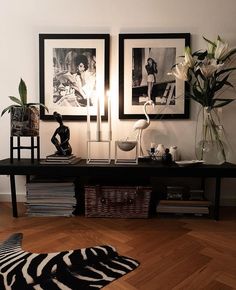 two framed pictures are on the wall next to a black and white zebra print rug