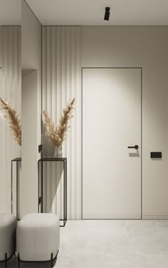 an empty room with two white stools and a plant in the corner next to it