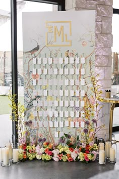 a table with flowers and candles on it next to a large sign that says eml