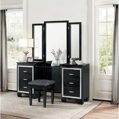 a black dresser with mirror and stool in a room