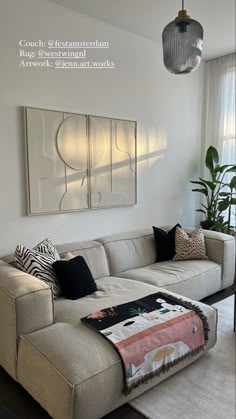 a living room with a couch, rug and large painting on the wall above it