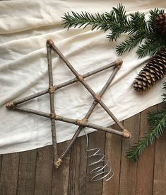 the star of david is made out of twigs and branches, next to pine cones