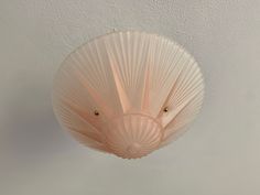 a light fixture hanging from the ceiling in a room with white walls and flooring