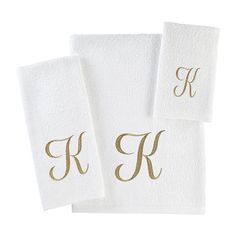 three white towels with gold monogrammed letters and the letter k on each towel