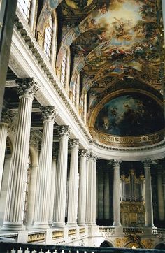 an ornate building with columns and paintings on the ceiling