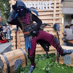 a man dressed in costume sitting on top of wooden barrels