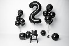 black balloons are arranged in the shape of numbers two and three on a white background